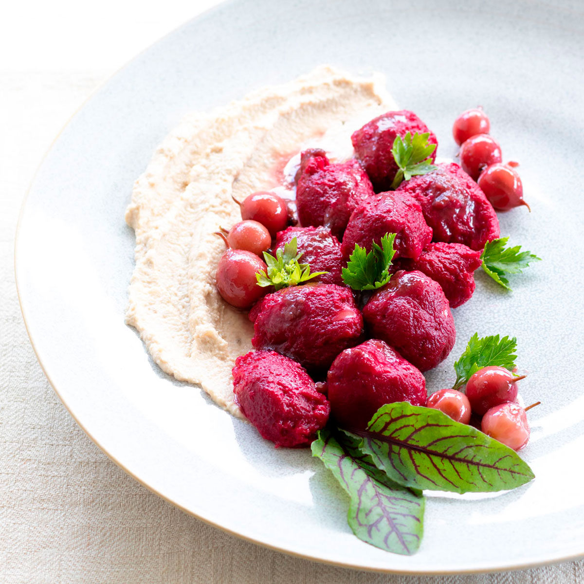 Beetroot ricotta gnocchi with celery cream on a bed of berries